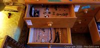 Wide view of two drawers full of assorted costume jewellery including necklaces, rings and earrings.
