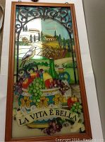 Full view of stained glass window showing fruit basket, bird, countryside and banner.