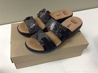 Pair of women's size 8 Clarks sandals with snake print straps shown on top of original box.