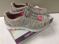 Pair of new Skechers relaxed fit women's shoes in beige tone with memory foam insole, displayed on top of their original box which states size 7.5 and wide fit.