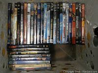 Top view showing DVDs including awkwardly stacked DVDs, some stacked sideways and some upright, titles include House of Cards, Bewitched, Minority Report, and others.