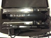 Electric carving knife set with blades and accessories neatly arranged inside black storage case.