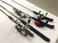 Four fishing rods laid out horizontally, showing reels and grips with clear color differences and some use wear.