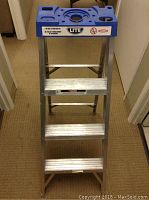 Front view of the 4 foot aluminum step ladder with blue top platform.
