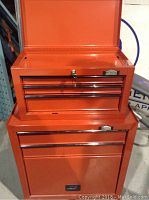 Orange Jobmate upper tool cabinet with three drawers, lockable top lid with key shown open