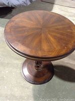 Top view of the round wooden table showing the sunburst pattern on the tabletop.