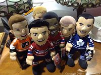 Seven NHL hockey plush toys representing players from Philadelphia Flyers, Montreal Canadiens and Toronto Maple Leafs in various skin tones and jersey designs.