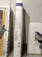 Tall white box with GlucksteinHome branding and printing, containing gazebo frame components