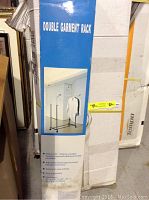 Photo of boxed double garment rack with product image and features on box.