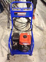 Front view of Simoniz S2500 power washer showing frame, engine, hose, and wand