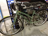 Side view of the green Autostream GT women's bike showing frame, seat, and tires.