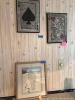 Two framed playing card prints (Ace of Spades and King of Hearts) hanging on a wall above a framed poem print.