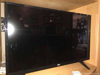 Front view of the LG 28 inch flat screen TV showing black bezel and screen surface.