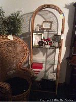 Front view of tall wicker shelf unit with glass shelves, showing natural wicker pattern and attached tags.