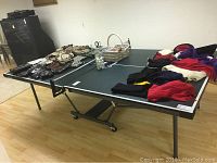 Full view of the Stiga ping pong table with paddles, balls, and other items placed on the surface.