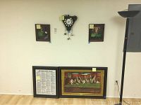 Four framed billiards pictures and one billiards themed clock hung on a white wall for display