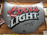Full view of car hood mounted on wall showing Coors Light graphics, Dodge emblem, and autograph.