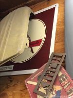 All three items shown together on wooden floor including signs and metal emblem