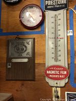 Overview of both plaque and thermometer mounted on wood wall