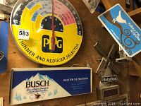 Photo showing the PPG wall thermometer and Busch Light Beer sign on a wooden wall, along with other items.