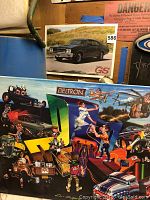 Photo showing Buick car poster behind colorful PPG Deltron metal sign with signature