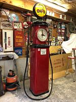 Full front view of red Tokheim pump with Indian Motorcycle globe topper and garage background