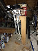 Front view of engine mounted on wooden stand showing fuel tank and controls