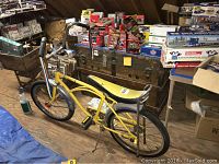 Side angle showing the full profile of the yellow vintage bike, frame and seat details