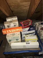 Photo showing the assortment of boxed collectible model cars on a blue fabric surface, with visible brands including Winross and Servistar.