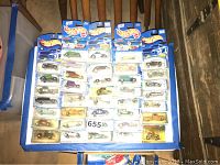 Top-down view of 35 unopened Hot Wheels cars in original packaging arranged on board