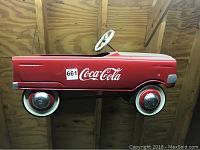 Right side view showing red metal body, Coca-Cola logo and white-wall wheels