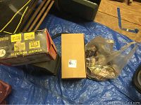 Photo showing StackIt brackets box, a small brown box, and a bag of assorted items on a blue tarp.