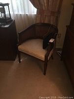 First wicker armchair with white upholstered seat and wooden frame, minor wear visible on armrest area.