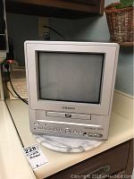Front view of the Orion 9 inch CRT TV with built-in DVD player placed on a marble surface.