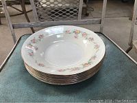 Stack of six Homer Laughlin floral trimmed bowls, cream colored with floral pattern and thin gold band