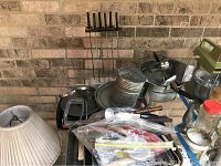 Overview of the assorted vintage kitchen items placed on a table against brick wall, including skewers, flour sifter, mixing bowls, and electric mixer.