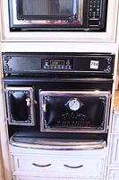 Front view closed showing decorative scroll design, digital control panel, gauge and Elmira Stove Works branding