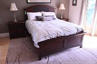 Full front view of assembled bed frame showing carved headboard, footboard and side rails