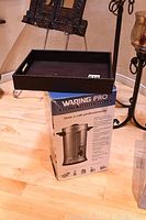 Original imaging showing black vinyl covered serving tray on top of the Waring Pro coffee urn box, the urn is inside the box, not visible.