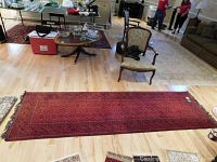 Full length of red runner rug on hardwood floor with furniture around