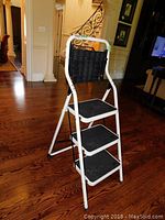 Front and side view of the white metal step ladder with three black steps and a black tool tray at the top.