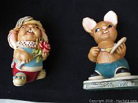 Photo of two rabbit figurines, one chubby with flower and one playing drum