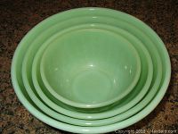 Four Fire King jadeite green swirl mixing bowls nested inside each other, showing size graduation and glaze condition.