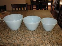Three robin's egg blue Fire King mixing bowls arranged side by side showing size comparison.