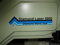 Close-up of side panel showing “Diamond Laser 5000 Diamond Band Saw” logo on beige cast metal housing