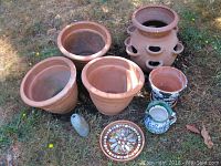 Overview of all pots together showing various sizes and styles including terracotta, mosaic, and strawberry pot