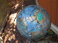 Close top view of blue and teal glass mosaic metal garden ball plant pot holder.
