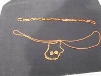 All items displayed on black fabric: three coral bead necklaces and one pair of coral earrings.
