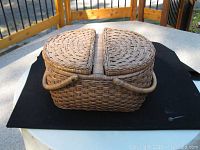 Closed woven vintage basket with hinged lid and handle, showing intact weaving and design.