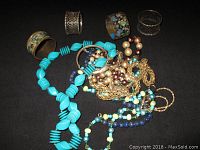 Overview of entire lot showing lapis lazuli style necklace, metal bracelets, gold-tone chains, and various bead necklaces